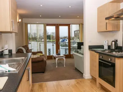 a kitchen and living room with a view of a boat at 4 Teal House in Carnforth
