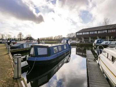 a blue boat is docked next to a building at 4 Teal House in Carnforth
