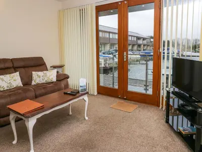 a living room with a couch and a table and a television at 4 Teal House in Carnforth