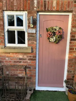 a pink door and a window on a brick house at Luxury two bedroom Loft in Croston
