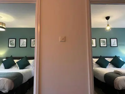 a bedroom with two beds and a mirror at Spacious 5 bedroom house in Fazakerley