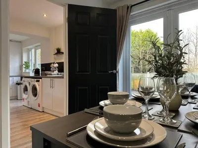 a dining room table with plates and wine glasses at Spacious 5 bedroom house in Fazakerley