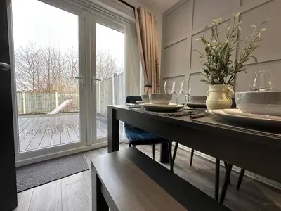a dining room with a table and a large window at Spacious 5 bedroom house in Fazakerley
