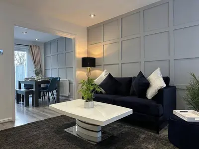 a living room with a couch and a table at Spacious 5 bedroom house in Fazakerley