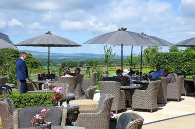 a group of people sitting at tables under umbrellas at Northcote in Langho