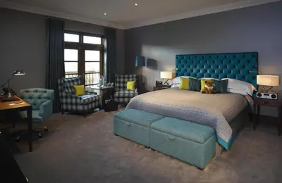 a bedroom with a large bed with a dog sitting on it at Northcote in Langho