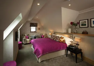 a bedroom with a purple bed in a attic at Northcote in Langho