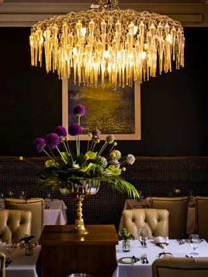 a dining room with a vase of flowers on a table at Northcote in Langho