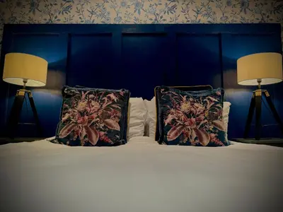 a blue bedroom with a bed with two pillows at Sleeps10-Parking-Garden-HotTub-PetFriendly in Blackpool