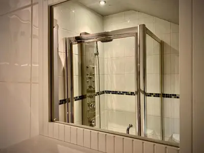 a bathroom with a shower with a mirror at Sleeps10-Parking-Garden-HotTub-PetFriendly in Blackpool