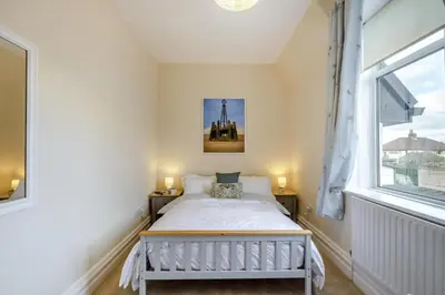 a bedroom with a bed and two windows at 3 Bed in Lytham St. Annes oc-m30622 in Saint Annes on the Sea