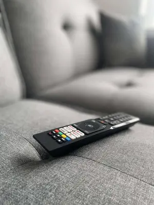 a remote control sitting on the arm of a couch at The Crescent-Modern Coastal Home in Blackpool