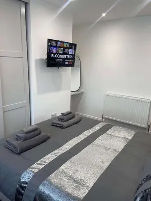 a room with a bed with a flat screen tv on the wall at The Crescent-Modern Coastal Home in Blackpool