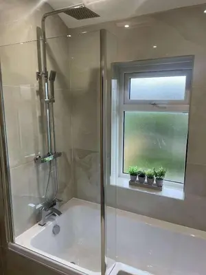 a bathroom with a shower and a window with potted plants at The Crescent-Modern Coastal Home in Blackpool