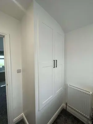 a room with a white wall with a cabinet at The Crescent-Modern Coastal Home in Blackpool