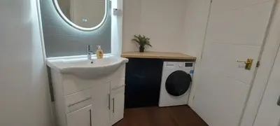 a bathroom with a sink and a washing machine at The Enigma - 2 Master bedrooms sleeps 6 in Blackpool