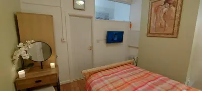a small bedroom with a bed and a mirror at The Enigma - 2 Master bedrooms sleeps 6 in Blackpool