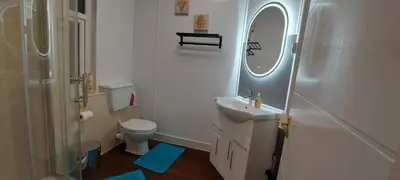 a bathroom with a sink and a toilet and a mirror at The Enigma - 2 Master bedrooms sleeps 6 in Blackpool