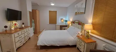 a bedroom with a white bed and a television at The Enigma - 2 Master bedrooms sleeps 6 in Blackpool
