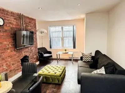 a living room with a couch and a brick wall at Castle Street 2 Bedroomed Next to The IVY in Liverpool