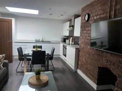 a kitchen and living room with a brick wall at Castle Street 2 Bedroomed Next to The IVY in Liverpool