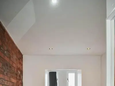 a white room with a mirror and a brick wall at Castle Street 2 Bedroomed Next to The IVY in Liverpool