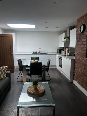a living room with a table and a kitchen at Castle Street 2 Bedroomed Next to The IVY in Liverpool