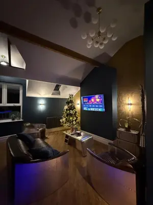 a living room with a christmas tree and a tv at The Loft At One Luxury Penthouse in Wigan