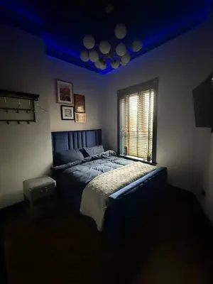 a bedroom with a large bed with a blue ceiling at The Loft At One Luxury Penthouse in Wigan