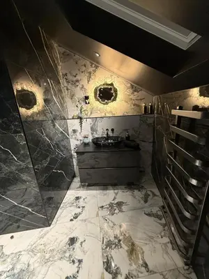 a bathroom with a sink and a marble wall at The Loft At One Luxury Penthouse in Wigan