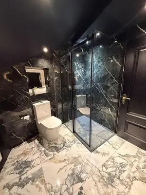 a bathroom with a toilet and a glass shower at The Loft At One Luxury Penthouse in Wigan