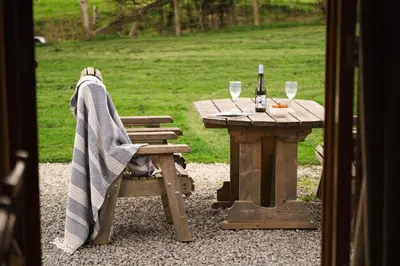 a picnic table with a blanket and a table with wine glasses at Ribble Valley by Wigwam Holidays in Langho
