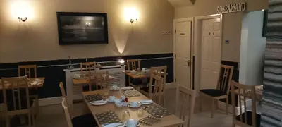 a dining room with a table and chairs and a television at The Norwood Hotel in Blackpool