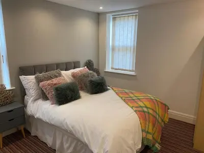 a bedroom with a bed with pillows and a window at Blackpool - 4 Beds - Sleeps 10 - Pet Friendly in Blackpool