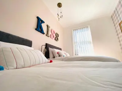 a bedroom with two white beds and a window at Blackpool - 4 Beds - Sleeps 10 - Pet Friendly in Blackpool