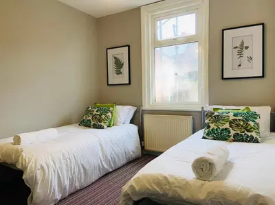two beds in a room with a window at Blackpool - 4 Beds - Sleeps 10 - Pet Friendly in Blackpool