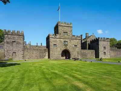a castle with a grass field in front of it at Irishman's Tower in Riley Green