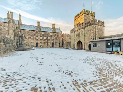 an empty courtyard of a castle with snow on the ground at Irishman's Tower in Riley Green