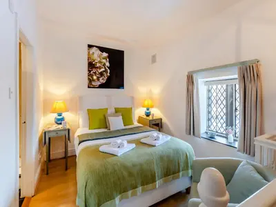 a bedroom with a bed and a chair and a window at Irishman's Tower in Riley Green