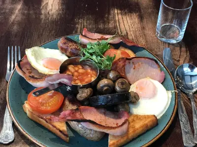 a plate of breakfast food with eggs bacon and mushrooms at Briardene in Blackpool