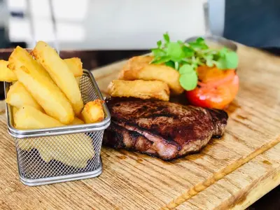 a plate of food with a steak and french fries at Briardene in Blackpool