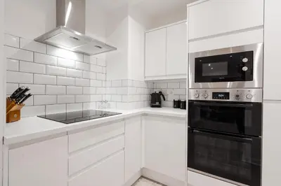a white kitchen with a sink and a stove at Brighton Street Apartment - 2 Bedroom Free Wi-Fi and Parking in Wallasey