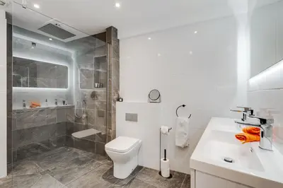 a bathroom with a toilet and a shower and a sink at Brighton Street Apartment - 2 Bedroom Free Wi-Fi and Parking in Wallasey