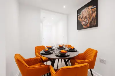 a dining room with a table and orange chairs at Brighton Street Apartment - 2 Bedroom Free Wi-Fi and Parking in Wallasey