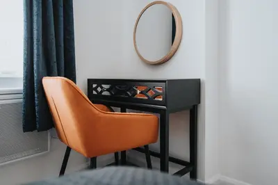 a mirror and a chair in a room at Brighton Street Apartment - 2 Bedroom Free Wi-Fi and Parking in Wallasey