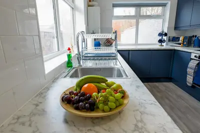 a bowl of fruit on a counter in a kitchen at Contractor Luxury Home - Long Stays - 4 Bedrooms - Sleep 8 - Zip & Link Beds - Ultra Fast WiFi - Free Parking in Birkenhead