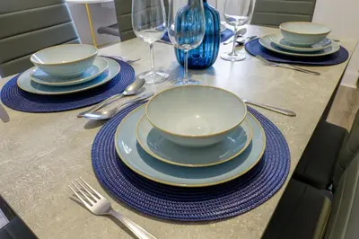 a table with plates and forks and wine glasses at Contractor Luxury Home - Long Stays - 4 Bedrooms - Sleep 8 - Zip & Link Beds - Ultra Fast WiFi - Free Parking in Birkenhead