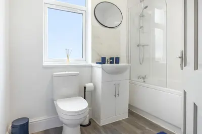 a white bathroom with a toilet and a sink at Contractor Luxury Home - Long Stays - 4 Bedrooms - Sleep 8 - Zip & Link Beds - Ultra Fast WiFi - Free Parking in Birkenhead