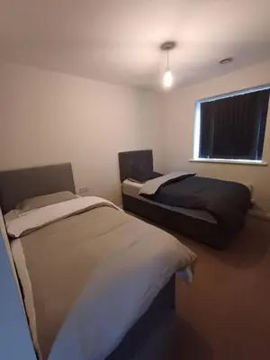 a bedroom with two beds and a window at Great Home in Liverpool