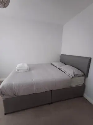 a bed in a room with a white wall at Great Home in Liverpool